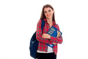 junge fröhliche Studentin mit Rucksack posiert isoliert auf weißem Hintergrund im Studio foto