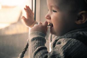 süßes kleines Mädchen, das aus dem Fenster schaut foto
