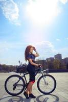 vertikales junges sexy Mädchen auf Fahrrad foto