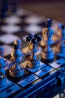 Schachbrett mit Schachfiguren auf blauem Hintergrund. konzept von geschäftsideen und wettbewerbs- und strategieideen. weißer König und Königin aus nächster Nähe. foto