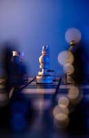 Schachbrett mit Schachfiguren auf blauem Hintergrund. konzept von geschäftsideen und wettbewerbs- und strategieideen. weißer Bauer aus nächster Nähe. foto