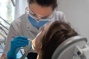 Zahnarzt behandelt einem Mädchen in einer Klinik Zähne