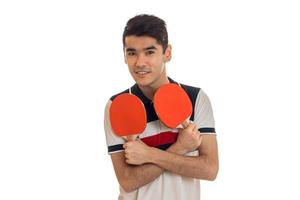 hübscher junger Sportler, der Tischtennis spielt und vor der Kamera lächelt, isoliert auf weißem Hintergrund foto