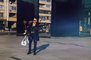 Geschäftsmann mit Sonnenbrille lächelt und schaut weg foto