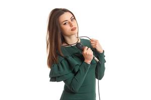 charmante brünette dame im grünen kleid mit mikrofon foto