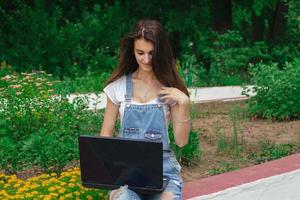 nettes junges Brunettemädchen, das einen Laptop verwendet foto