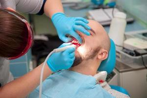 Typ reinigt eine Plakette an einem Empfang beim Zahnarzt