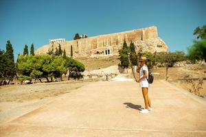 Mädchen macht eine Tour durch die antike Akropolis in Griechenland foto