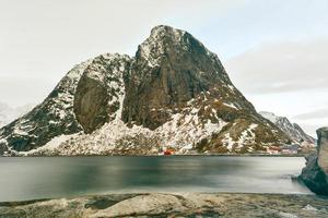Fischerhütte in den Berggipfeln Hamnoy und Lilandstinden im Winter in Reine, Lofoten-Inseln, Norwegen. foto