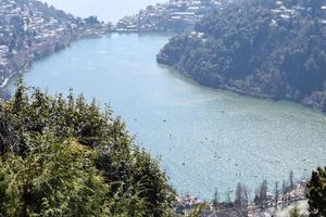 volle ansicht des naini-sees während der abendzeit nahe der einkaufsstraße in nainital, uttarakhand, indien, schöne ansicht des nainital-sees mit bergen und blauem himmel foto