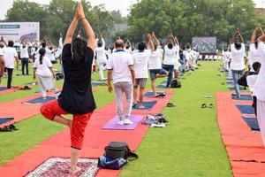 Gruppen-Yoga-Übungssitzung für Menschen verschiedener Altersgruppen im Cricket-Stadion in Delhi am internationalen Yoga-Tag, große Gruppe von Erwachsenen, die an Yoga-Sitzungen teilnehmen foto