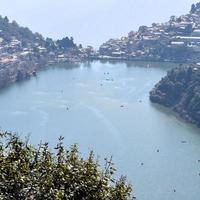 volle ansicht des naini-sees während der abendzeit nahe der einkaufsstraße in nainital, uttarakhand, indien, schöne ansicht des nainital-sees mit bergen und blauem himmel foto