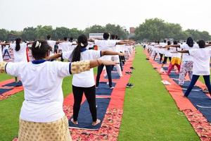 Gruppen-Yoga-Übungssitzung für Menschen verschiedener Altersgruppen im Cricket-Stadion in Delhi am internationalen Yoga-Tag, große Gruppe von Erwachsenen, die an Yoga-Sitzungen teilnehmen foto