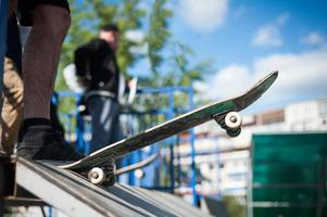 Skateboarder macht den Trick mit einem Sprung auf die Rampe. Skateboardfahrer, der in die Luft fliegt foto