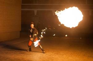 verschwommene Sicht, Feuershow. Männer machen Feuerkreise. unscharfer Hintergrund foto