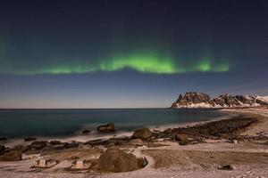 Nordlichter über dem Meer am Strand von Utakleiv, Lofoten, Norwegen im Winter. foto