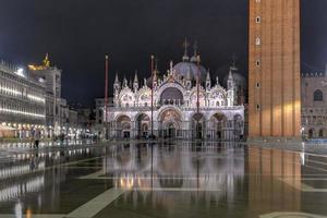 Markusplatz in Venedig bei Nacht mit Spiegelungen im Wasser. foto