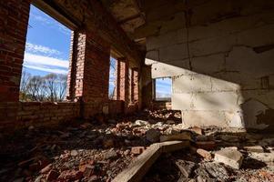 verlassene und zerstörte Büros und Hallen, ein zerstörtes Industriegebäude, ein Haus mit zerbrochenen Fenstern, alte zerstörte Häuser. foto