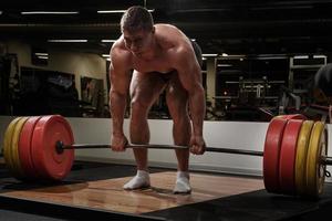 starker mann, der im fitnessstudio kreuzheben macht foto