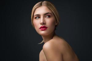 blonde Frau mit roten Lippen posiert im Studio foto