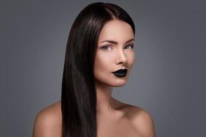 Frau mit glattem Haar und schwarzen Lippen foto