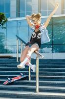 stilvolles Mädchen mit einem Skateboard auf der Straße foto