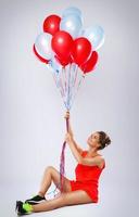 glückliche Frau mit vielen bunten Luftballons foto