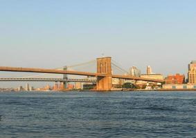 brooklyn bridge gegen die skyline von new york bei sonnenuntergang foto