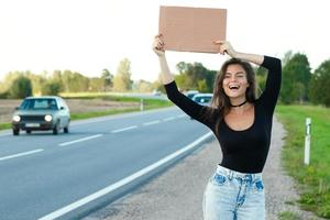 Tramper auf der Straße hält ein leeres Pappschild foto