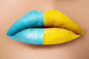 Closeu der weiblichen Lippen mit zwei verschiedenen Lippenstiften foto