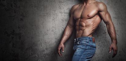 muskulöser Oberkörper eines Mannes in Jeans foto