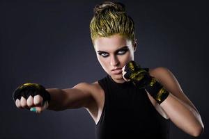 Frau MMA-Kämpferin mit gelben Haaren im Studio foto