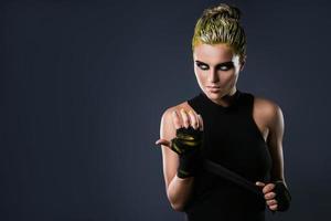 Frau MMA-Kämpferin mit gelben Haaren im Studio foto