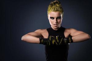 Frau MMA-Kämpferin mit gelben Haaren im Studio foto