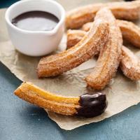 hausgemachte Churros mit Zimtzucker auf Pergament foto