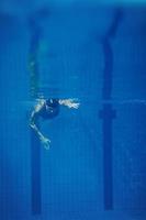 Schwimmerin unter Wasser während ihres Trainings im Pool foto