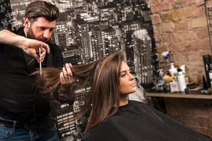 friseur während der arbeit mit schöner klientin im salon foto