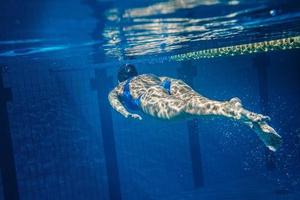 Schwimmerin unter Wasser während ihres Trainings im Pool foto