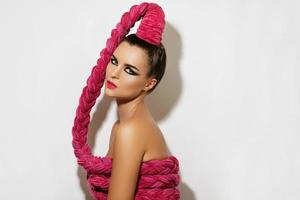 junge sexy Frau mit einem langen rosa Zopf im Haar foto
