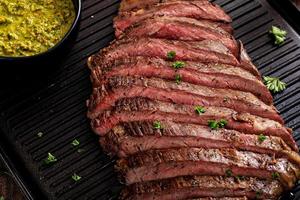 gebratenes Flankensteak auf einer Grillpfanne mit Chimichurri und Meerrettich foto