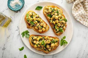 Gesundes Bruschetta mit Kichererbsensalat und Kräutern foto