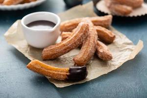 hausgemachte Churros mit Zimtzucker auf Pergament foto