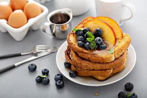 Stapel French Toast mit frischen Pfirsichen und Heidelbeeren foto