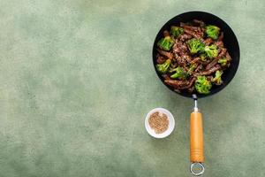 Rindfleisch und Brokkoli in einem kleinen Wok anbraten foto