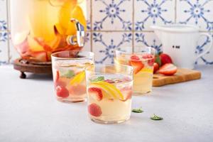 Sommer-Sangria-Punsch in einem Krug und Gläsern foto