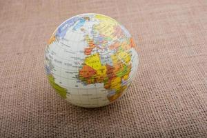 Globus auf einem braunen Stoffhintergrund foto