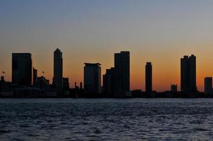 Skyline-Silhouette von New Jersey in der Abenddämmerung über dem Hudson River in New York City. foto