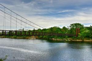 die androscoggin swinging bridge ist eine fußgängerhängebrücke, die den androscoggin river zwischen dem stadtteil topsham heights in topsham, maine, und dem benachbarten brunswick überspannt. foto