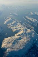 eine luftaufnahme der schneebedeckten berge der fjorde norwegens im winter. foto