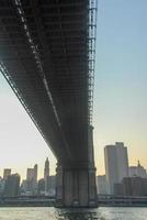 brooklyn bridge gegen die skyline von new york bei sonnenuntergang foto